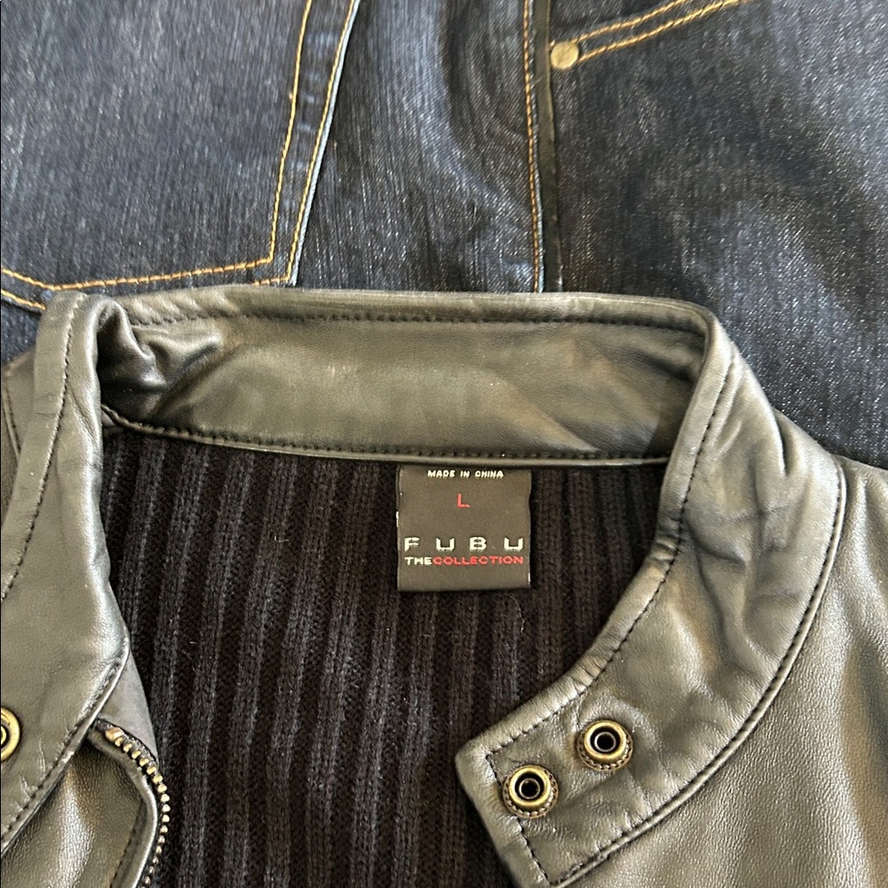 FUBU Black Leather Jacket with Gold Accents and dark denim Jean pants.